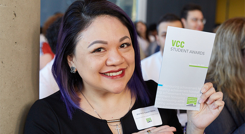 A student holding up an event program