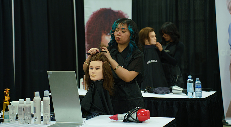 A hairstyling student cutting mannequin's hair