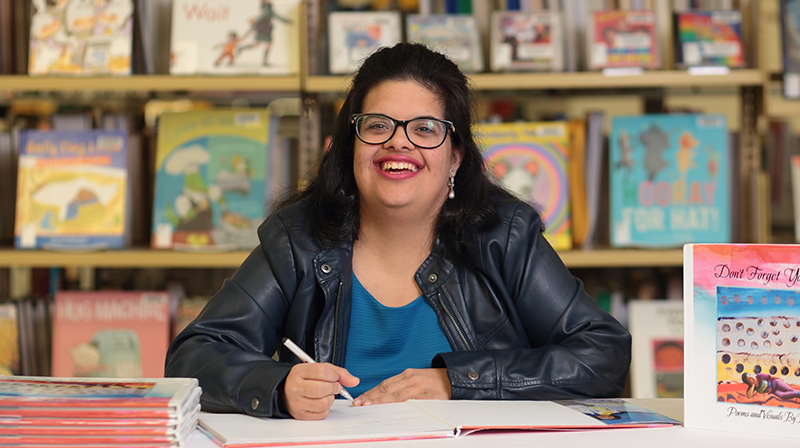 Roshni Kashyap smiling with copies of her book